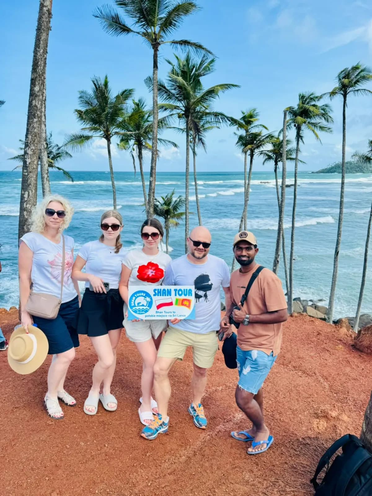 A group at a palm-lined viewpoint above the southern coast