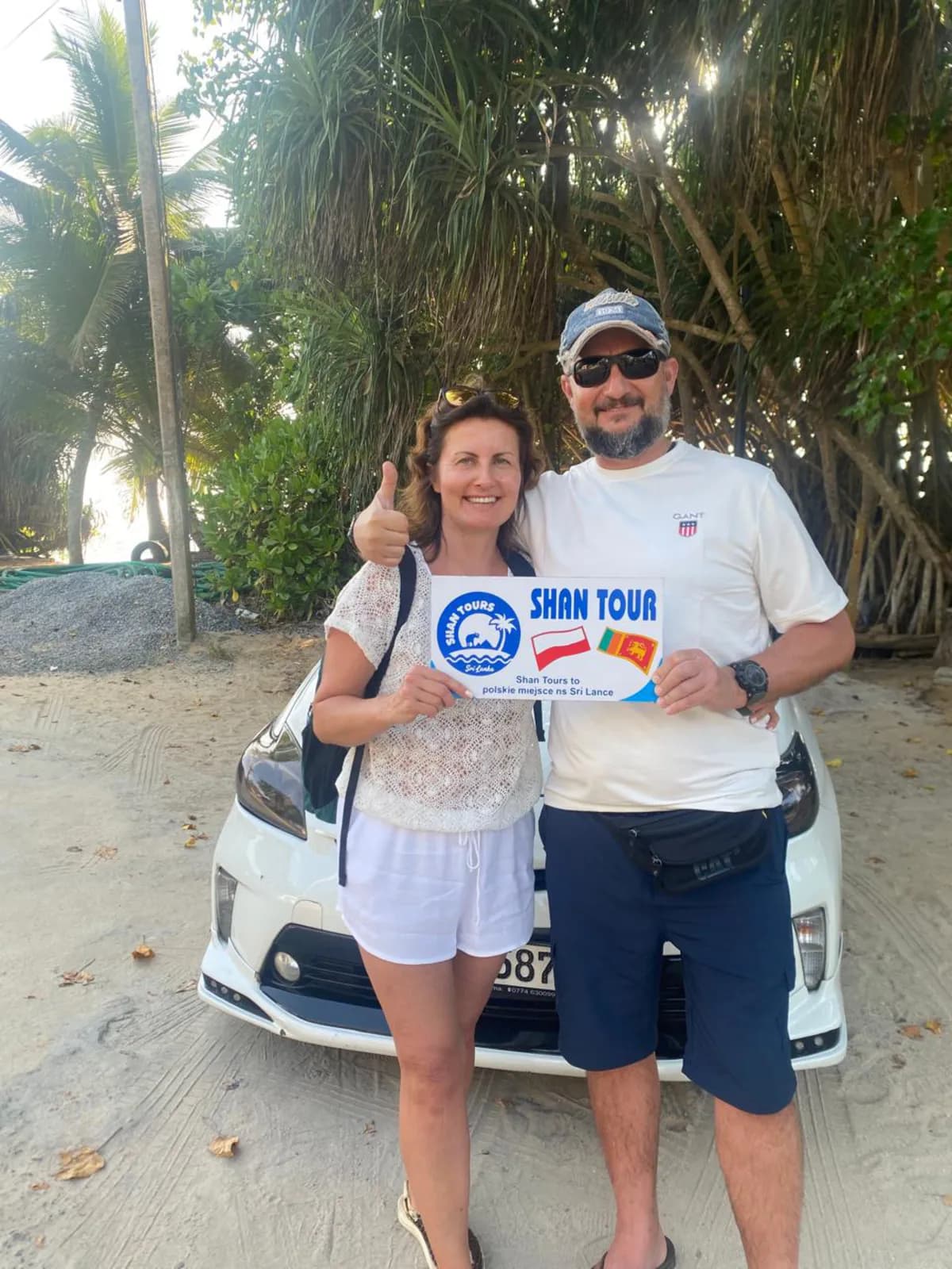 A couple with the Shan Tours board beside their private vehicle