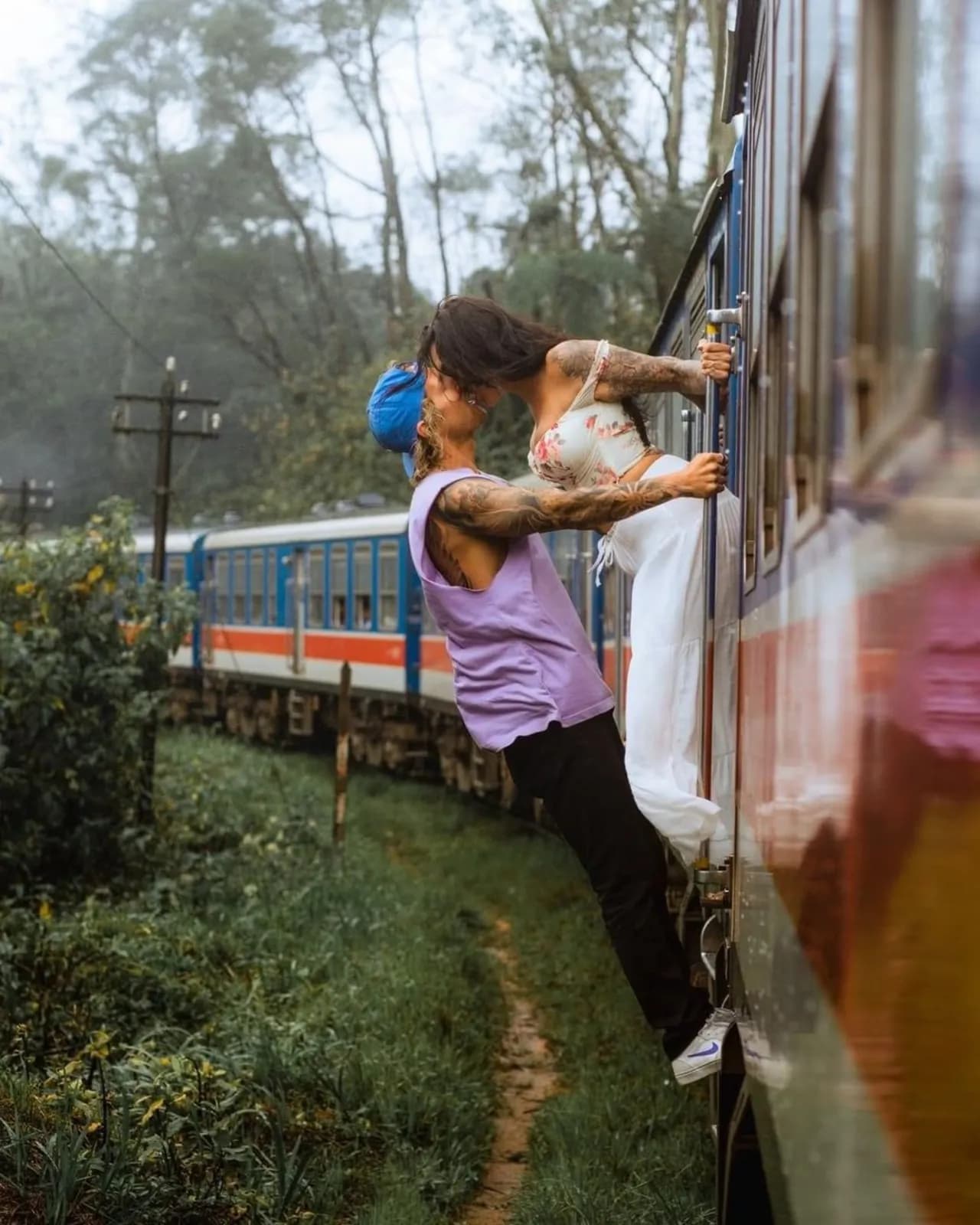 A traveller leaning from the doorway of a hill-country train