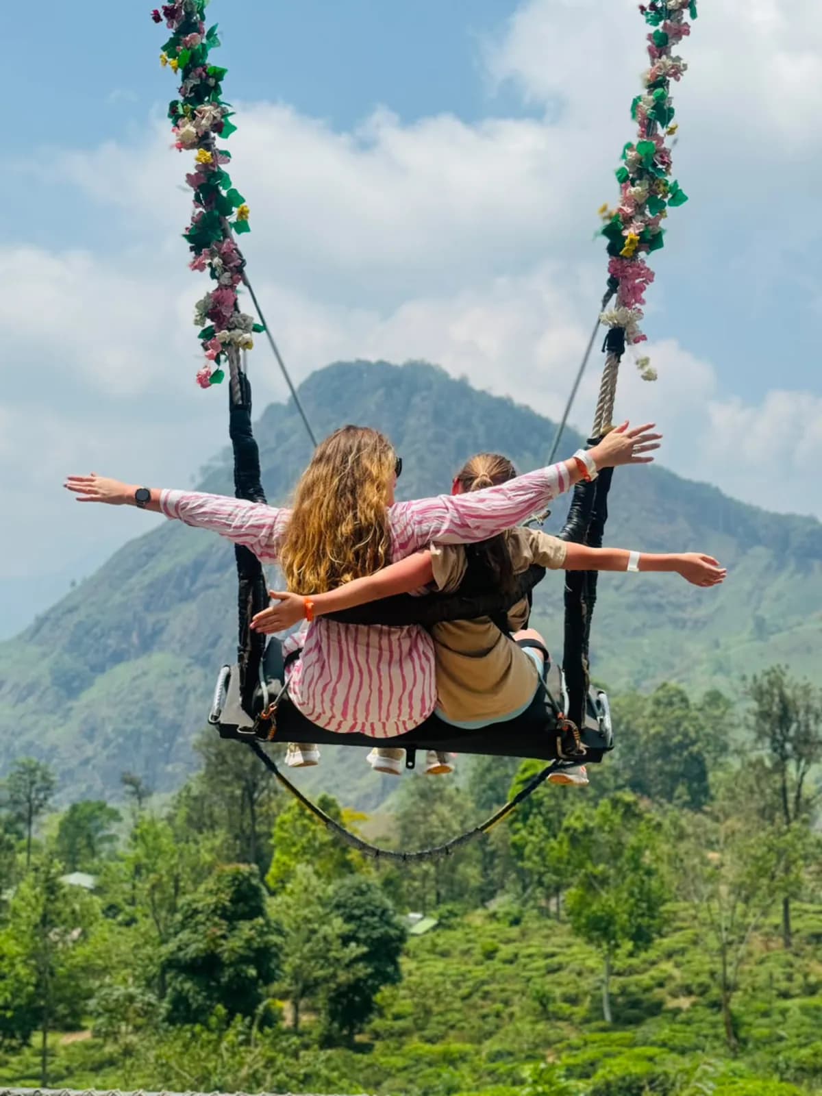 Two friends on a flower swing above the hill country