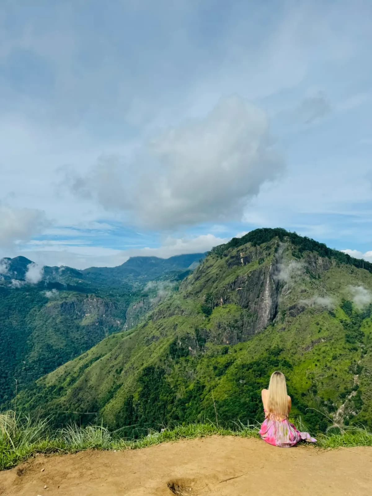A traveller sitting at a hill-country summit viewpoint
