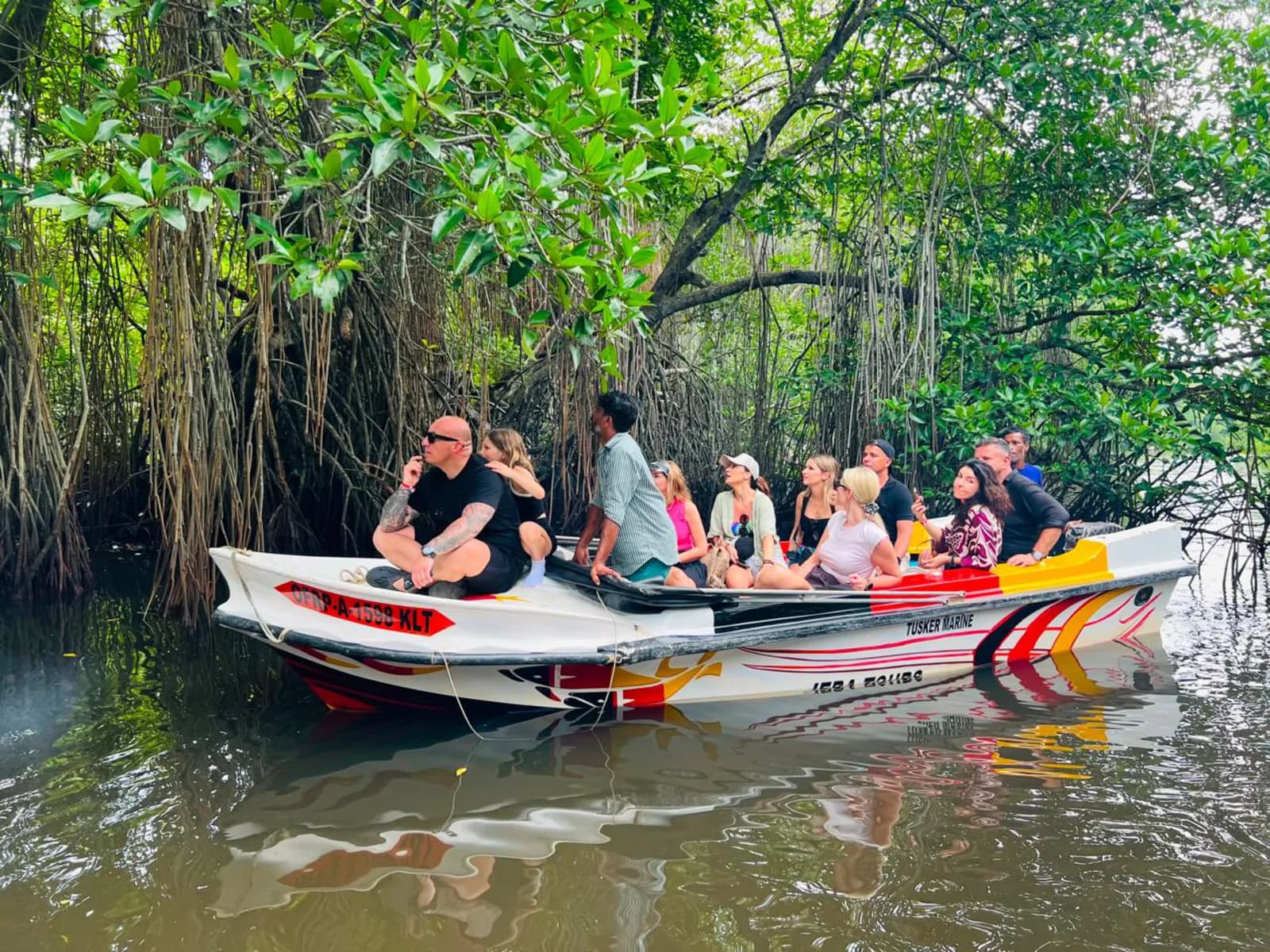 A boat of travellers on a mangrove river safari