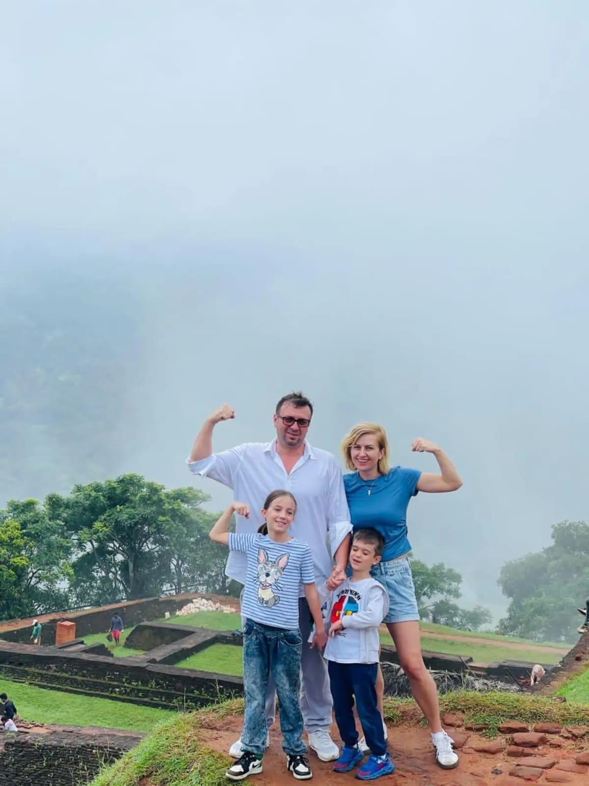 A family at a misty hilltop ruin