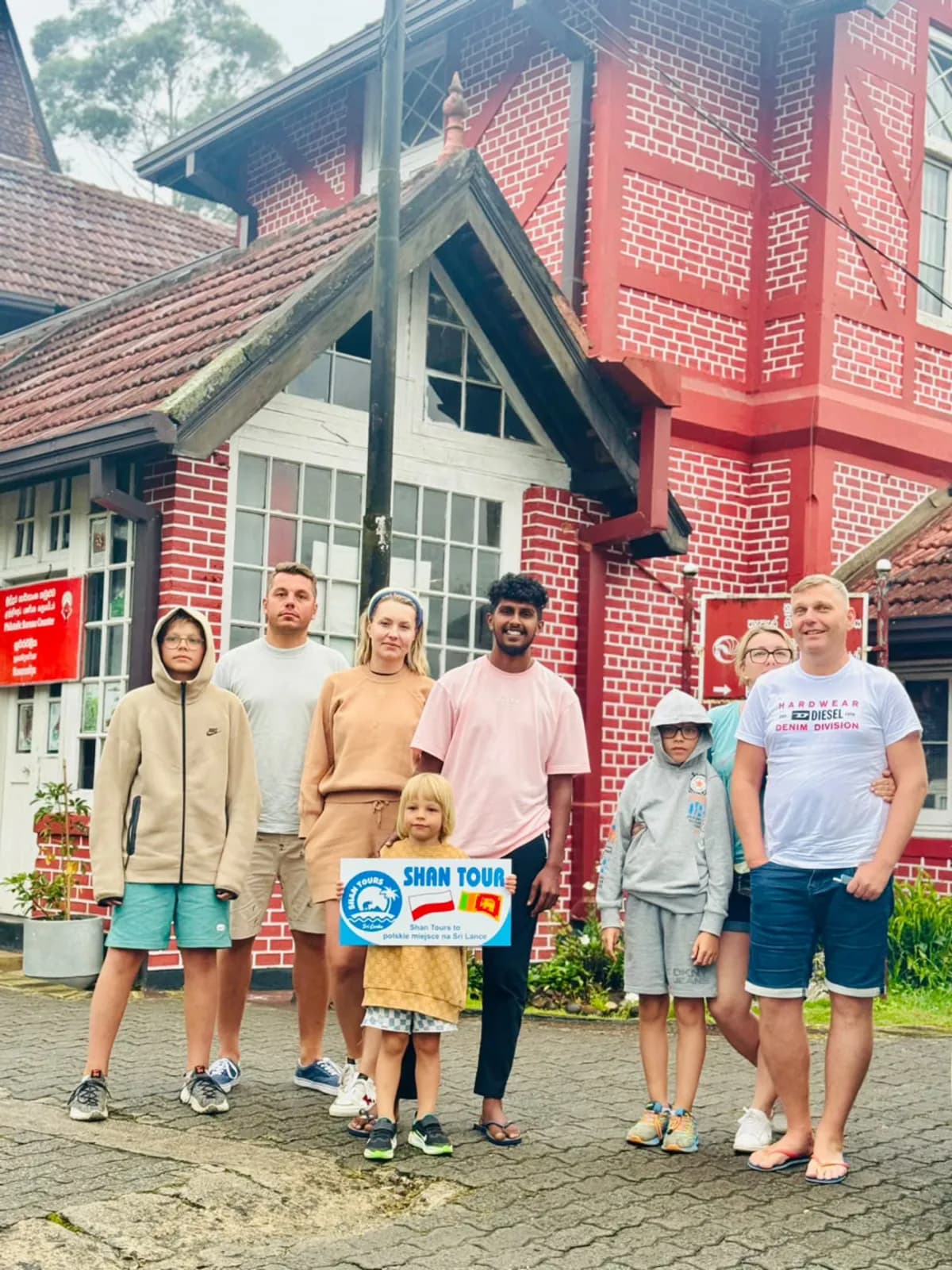A group with the Shan Tours board outside the red Nuwara Eliya post office