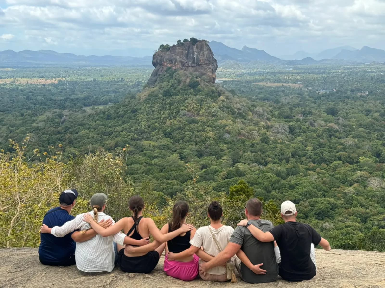 Travellers sitting on Pidurangala rock looking across to Sigiriya