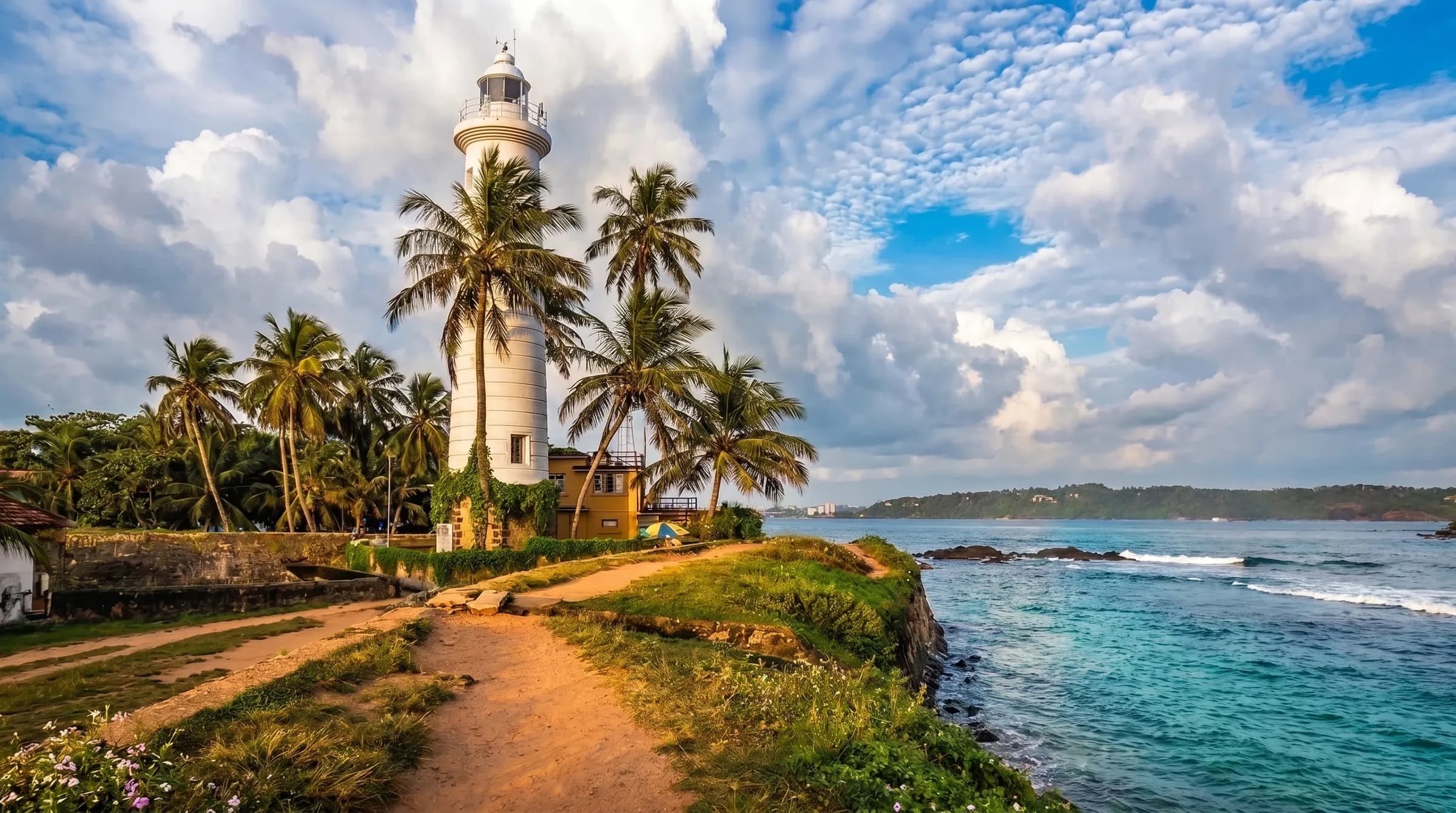 The lighthouse and palm-lined rampart path of Galle Fort above the Indian Ocean